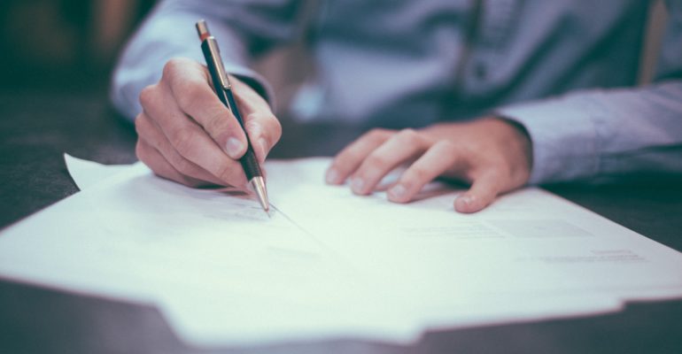 man writing on paper